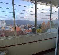 Na predaj veľkometrážny 3 izbový byt Žarnovica - Výhľad z 3-izbového bytu na Fraňa Kráľa v Žarnovici s panorámou mesta a hôr.