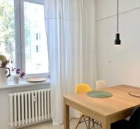 Na prenájom 2 izbový byt, 56 m2, Bratislava, Staré Mesto, Björnsonova - Svietidlo nad dreveným stolom, biele záclony a dekór kvetov na parapete v 2-izbovom byte.