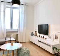 Na prenájom 2 izbový byt, 56 m2, Bratislava, Staré Mesto, Björnsonova - Obývacia izba v 2-izbovom byte s televízorom, pohovkou a podlahou s dreveným dekorom.