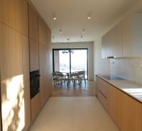 Prenájom 4 izbového bytu s krásnym výhľadom na mesto - Kuchyňa v 4-izbovom byte s podlahou s dreveným dekorom a svetlou kuchynskou linkou.