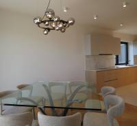 Prenájom 4 izbového bytu s krásnym výhľadom na mesto - Jedáleň s preskleným stolom a stoličkami, 4-izbový byt, podlaha s dreveným dekorom.