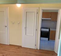 I prenájom štýlových izieb v 3-izbovom byte – Karlova Ves - Interiér 3-izbového bytu s podlahou s dreveným dekorom a kuchynskou linkou.