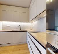 | Prémiové bývanie v ZWIRNe I Pekný zariadený 2i byt I - Kuchyňa v 2-izbovom byte so zabudovanými spotrebičmi a podlahou s dreveným dekorom.