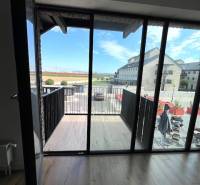 PREDAJ VEĽKORYSÝ 2 IZBOVÝ BYT NOVOSTAVBA DESINGN CENTER - Výhľad z 2-izbového bytu na balkón s podlahou s dreveným dekorom.