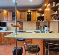 Predaj: Rodinný dom po rekonštrukcii s nadstavbou v Ochodnici (RCZ) - Kuchyňa v rodinnom dome s drevenými skrinkami, barovým pultom a spotrebičmi.