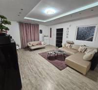 RODINNÝ DOM, HERNÁDKAK, MAĎARSKO - Obývačka v rodinnom dome s podlahou s dreveným dekorom a veľkou sedačkou.