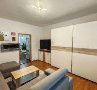 Na predaj rodinný dom v Trnovci nad Váhom - Obývačka v rodinnom dome s podlahou s dreveným dekorom, sedačkou a obrazmi na stene.