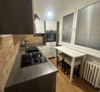 2-izb. byt, Nejedlého, Dúbravka, izby samostatné - Kuchyňa v 2-izbovom byte s podlahou s dreveným dekorom a plynovým sporákom.