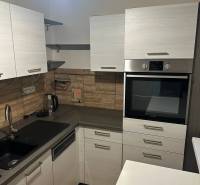 2-izb. byt, Nejedlého, Dúbravka, izby samostatné - Kuchyňa v 2-izbovom byte, s podlahou s dreveným dekorom a vstavanou rúrou.