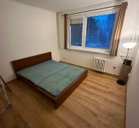 2-izb. byt, Nejedlého, Dúbravka, izby samostatné - Spálňa v 2-izbovom byte s posteľou a podlahou s dreveným dekorom.