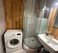 2-izb. byt, Nejedlého, Dúbravka, izby samostatné - Kúpeľňa v 2-izbovom byte s práčkou, sprchovým kútom a umývadlom, drevený dekor stien.