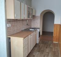 2-izbový byt s lodžiou, Turčianske Teplice - Kuchyňa v 2-izbovom byte s podlahou s dreveným dekorom a oblúkovým priechodom.