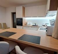 Lukratívny a priestranný 2-izbový apartmán v Mlynici na prenájom - Kuchyňa v 2-izbovom byte so vstavanými spotrebičmi a podlahou s dreveným dekorom.