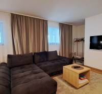 Lukratívny a priestranný 2-izbový apartmán v Mlynici na prenájom - Obývacia izba v 2-izbovom byte s pohodlnou sedacou súpravou a podlahou s dreveným dekorom.