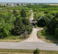 PREDAJ - Pozemok s výmerou do 196.000 m2 - 10 km Nitra, 20 km Šurany - Cesta ohraničená zeleňou poskytuje výhľad na komerčné pozemky v Ivanke pri Nitre.