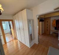 3 izbový byt 83 m² 2x balkón  Žiar nad Hronom centrum na predaj  - Chodba v 3-izbovom byte s podlahou s dreveným dekorom, bielymi skriňami a zrkadlom.