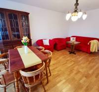 I Prenájom priestranného 4-izb.bytu, 2x balkón, parkovanie - Drevená vitrína, červená sedacia súprava a jedálenský stôl s kvetmi v 4-izbovom byte.