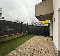 Novostavba 2 izbový byt s terasou a garážovým parkovacím miestom Nitra - Terasa pri 2-izbovom byte na Hornostavskej ulici v Nitre, s výhľadom na susedné budovy.