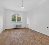 I PREDAJ Priestranný 3-izb. byt v centre Krížna/Blumentálska - Prázdna miestnosť s bielymi stenami a podlahou s dreveným dekorom v 3-izbovom byte.