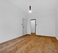 I PREDAJ Priestranný 3-izb. byt v centre Krížna/Blumentálska - Izba v 3-izbovom byte s bielymi stenami a podlahou s dreveným dekorom.