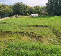 Predaj 4-izbového rodinného domu s veľkou záhradou v Semerove - Záhrada pri rodinnom dome v Semerove, so zeleňou a stromami na okraji pozemku.