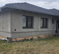 Predaj 4-izbového rodinného domu s veľkou záhradou v Semerove - Rodinný dom z neomietnutých stien v Semerove s šindľovou strechou na trávnatom pozemku.