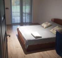 Predaj 4-izbového rodinného domu s veľkou záhradou v Semerove - Spálňa v rodinnom dome s posteľou a podlahou s dreveným dekorom.