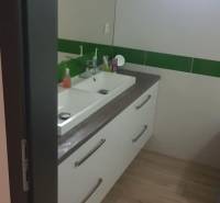 Predaj 4-izbového rodinného domu s veľkou záhradou v Semerove - Kúpeľňa v rodinnom dome s umývadlom a podlahou s dreveným dekorom.