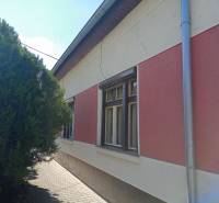 Na predaj rodinný dom v super lokalite - Rodinný dom v Nových Zámkoch so sieťami na zateplenej fasáde a stromom pri chodníku.