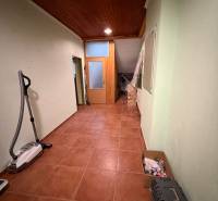 Veľký rodinný dom Podhradie  - Chodba v rodinnom dome s dlažbou, dreveným stropom a odkladacím priestorom.