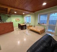 Veľký rodinný dom Podhradie  - Obývací priestor s jedálenským stolom, dreveným stropom a posteľou v Rodinnom dome.