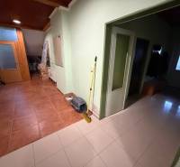 Veľký rodinný dom Podhradie  - Chodba rodinného domu s dlažbou, dverami a vešiakmi na oblečenie.