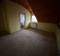 Veľký rodinný dom Podhradie  - Izba v podkroví rodinného domu s dreveným stropom a výhľadom na mesto.