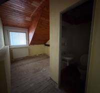 Veľký rodinný dom Podhradie  - Podkrovná izba s dreveným stropom a susediacou kúpeľňou v rodinnom dome.
