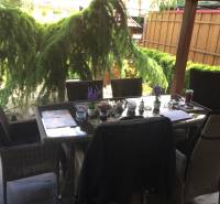 KRÁSNY DVOJPODLAŽNÝ RODINNÝ DOM NA PRENÁJOM - Rodinný dom s posedením na terase, vrátane podlahy s dreveným dekorom a záhradnej zelene.