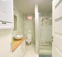 KRÁSNY DVOJPODLAŽNÝ RODINNÝ DOM NA PRENÁJOM - Kúpeľňa v rodinnom dome s umývadlom, sprchovým kútom a toaletou, svetlé dlažby.