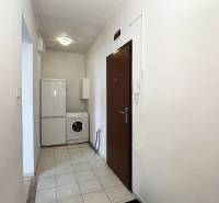 Exkluzívne | Na prenájom priestranný 1i byt Ružinove - Predsieň 1-izbového bytu s práčkou a chladničkou. Biele steny, keramická podlaha.