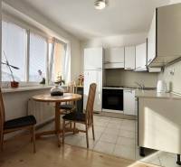 Exkluzívne | Na prenájom priestranný 1i byt Ružinove - Kuchyňa v 1-izbovom byte s okrúhlym stolom a podlahou s dreveným dekorom.