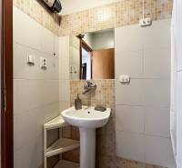 Exkluzívne | Na prenájom priestranný 1i byt Ružinove - Kúpeľňa v 1-izbovom byte s umývadlom, zrkadlom a bielymi obkladačkami.