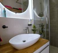 Moderný, rekonštruovaný 3i byt, pivnica, Jašíkova ul., Ružinov - Pošeň - Kúpeľňa so sprchovým kútom, umývadlom a podlahou s dreveným dekorom v 3-izbovom byte.