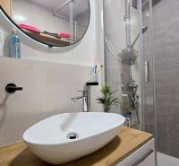 Moderný, rekonštruovaný 3i byt, pivnica, Jašíkova ul., Ružinov - Pošeň - Kúpeľňa v 3-izbovom byte s umývadlom na drevenom dekore, zrkadlom a sprchovým kútom.