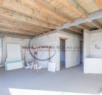 NA PREDAJ polyfunkčná budova v centre obce Veľké Leváre - Budova vo výstavbe s dreveným stropom a stavebným materiálom v interiéri.