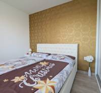 ŠTÝLOVÝ 3,5-IZBOVÝ BYT S NÁBYTKOM NA MIERU, A. HLINKU, ZVOLEN - Spálňa s vianočnými obliečkami, tapetou a kvetmi v 3-izbovom byte.