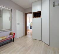 ŠTÝLOVÝ 3,5-IZBOVÝ BYT S NÁBYTKOM NA MIERU, A. HLINKU, ZVOLEN - Predsieň 3-izbového bytu s veľkým zrkadlom, lavičkou a podlahou s dreveným dekorom.