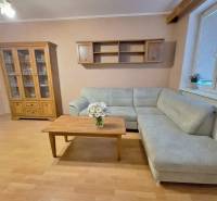 Predaj 2 izbový byt s dvoma balkónmi v Nižnej. - Obývačka v 2-izbovom byte s rohovou sedačkou, drevený dekor dopĺňa interiér.