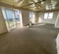 DOKONČENÁ NOVOSTAVBA,SOĽ-VRANOV N. TOPĽOU,MOŽNÁ DOHODA - Priestorná miestnosť v rodinnom dome so surovou betónovou podlahou, veľké okná poskytujú dostatok svetla.