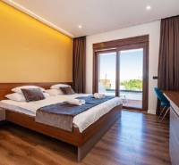 Novalja – luxusná vila s bazénom, jacuzzi a výhľadom na more - Elegantná spálňa vo vile s posteľou a podlahou s dreveným dekorom.