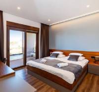 Novalja – luxusná vila s bazénom, jacuzzi a výhľadom na more - Izba s posteľou vily, podlaha s dreveným dekorom, balkón s výhľadom.