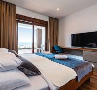 Novalja – luxusná vila s bazénom, jacuzzi a výhľadom na more - Spálňa vo Vile s podlahou s dreveným dekorom, posteľou, TV a výhľadom na terasu.