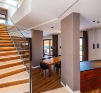 Novalja – luxusná vila s bazénom, jacuzzi a výhľadom na more - Interiér vily s drevenou podlahou, schodišťom a jedálenským stolom.